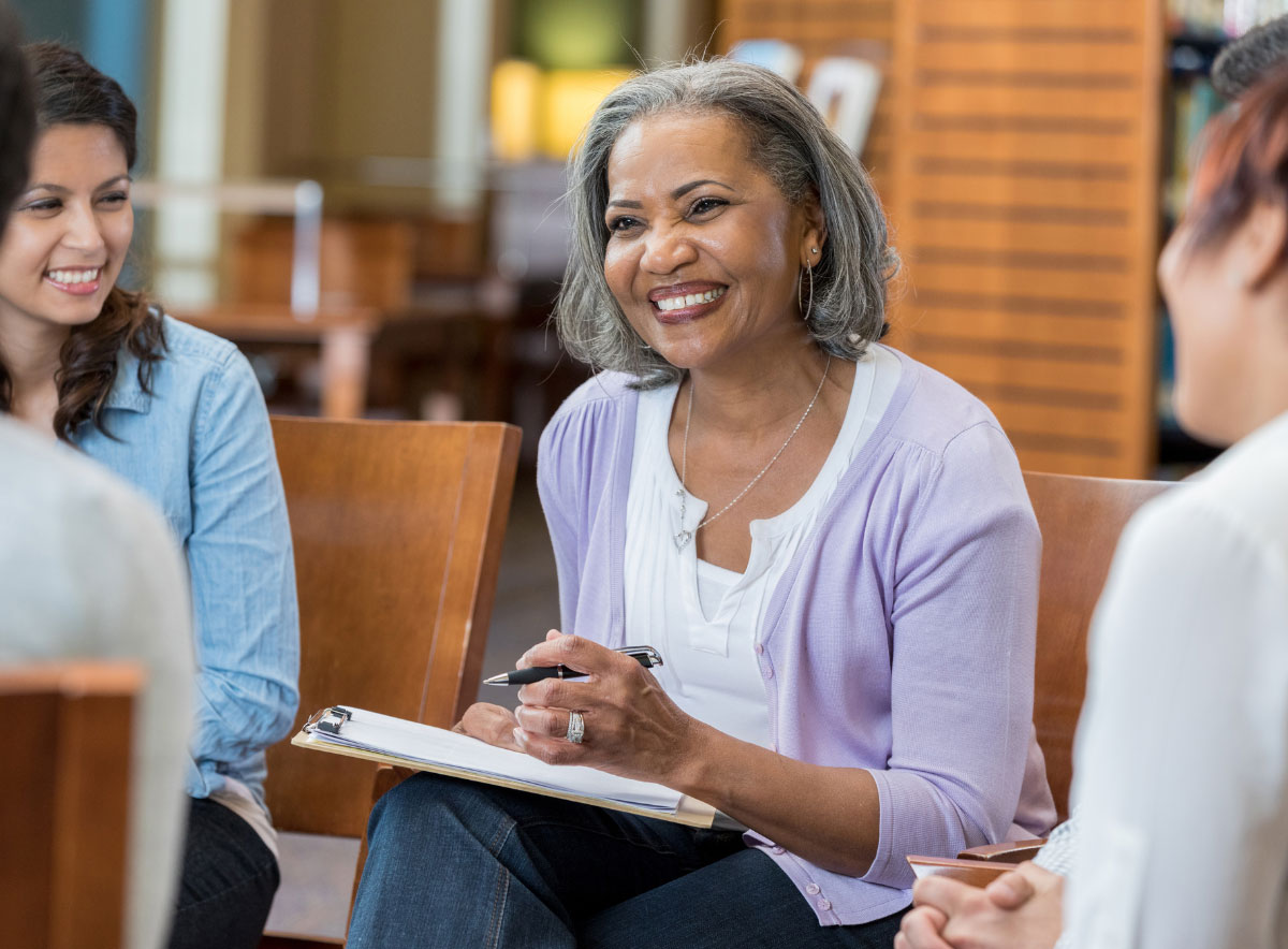 Woman supervisor smiling while speaking with child care center staff