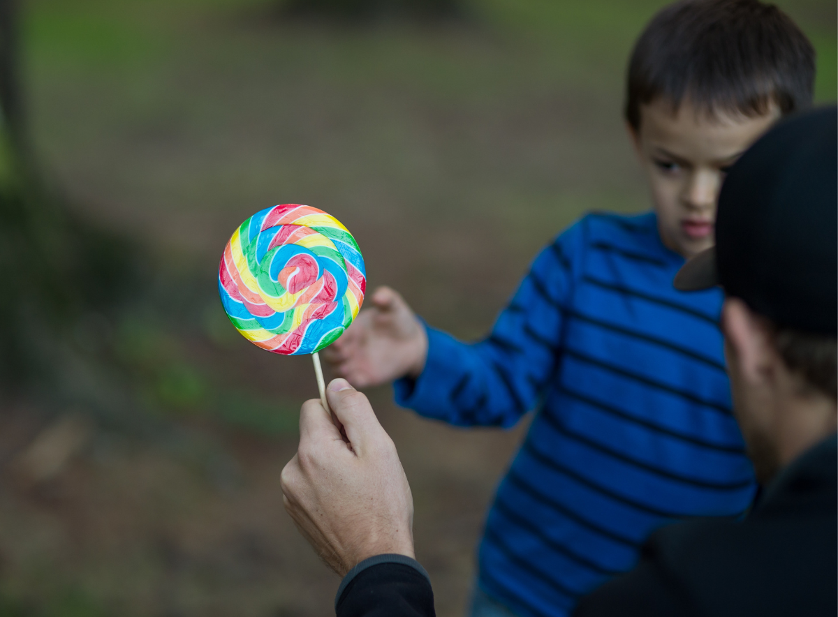 Stranger offers rainbow lollipop to hesitate young boy