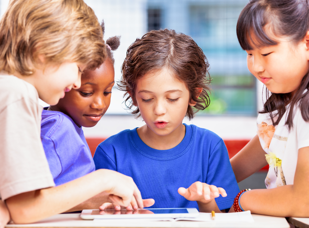 Children working together and looking at a tablet handheld device