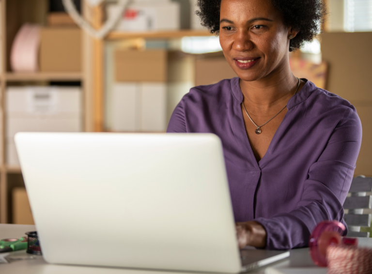 Woman smiling and typing on her laptop