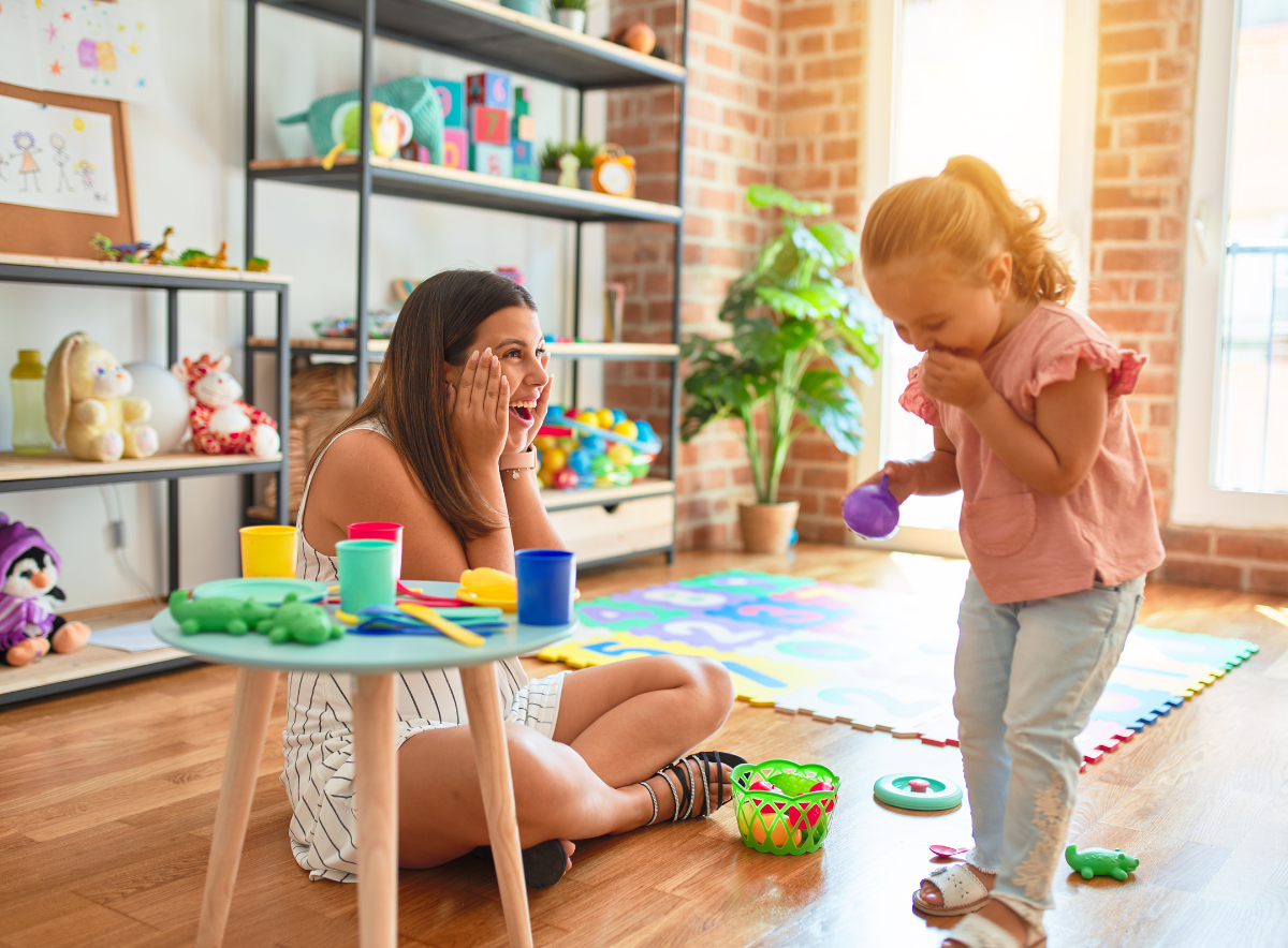 Woman playing with a young girl at a child care center