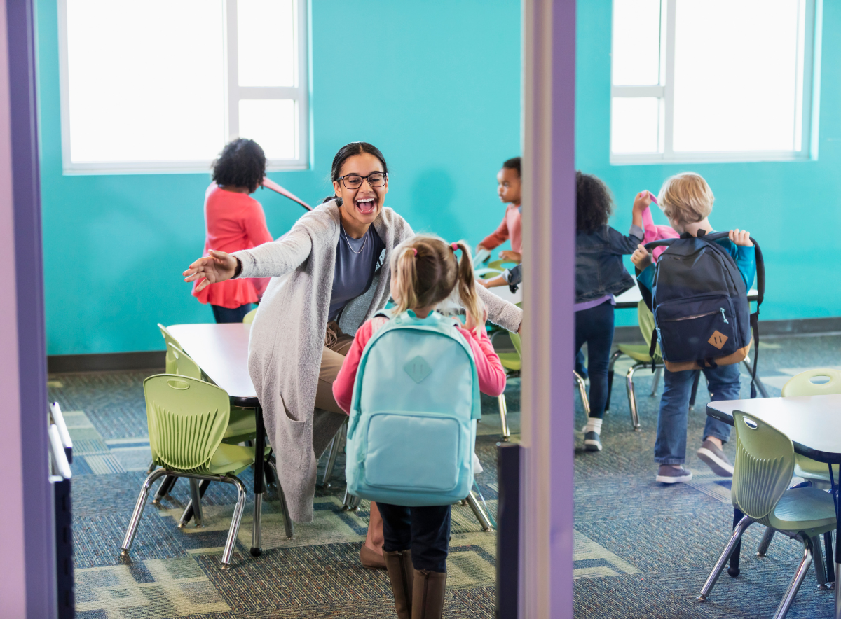 Teacher welcoming a new student to a child care center