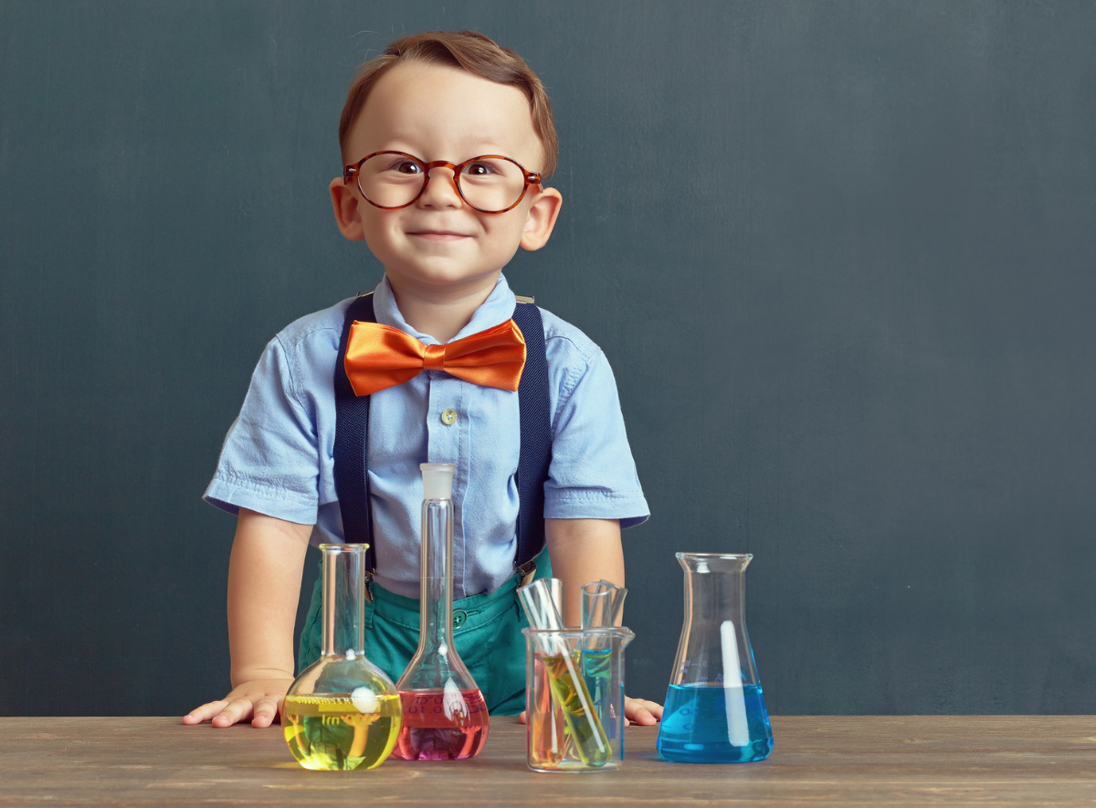 Boy with colorful early learning chemistry lab beakers