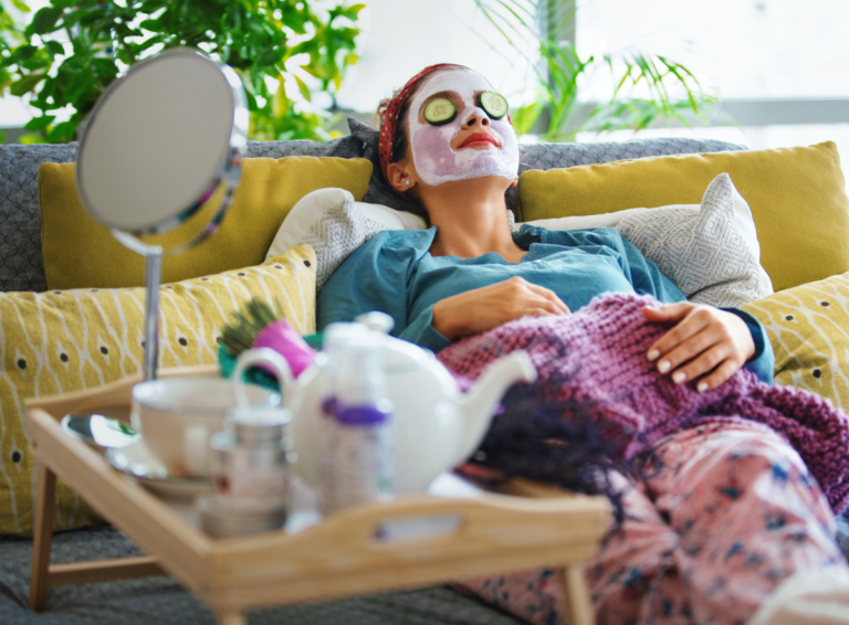 Woman relaxing on a couch and reducing stress with face mask