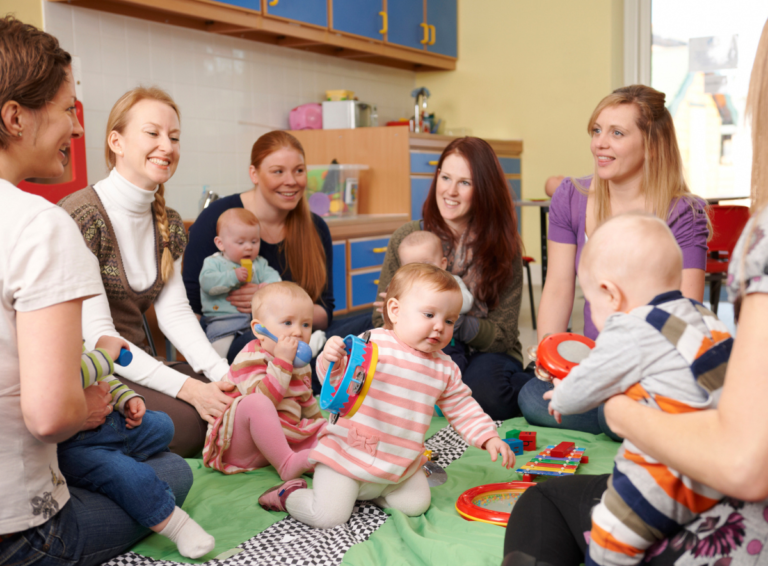 Parents sitting with babies in a child care center