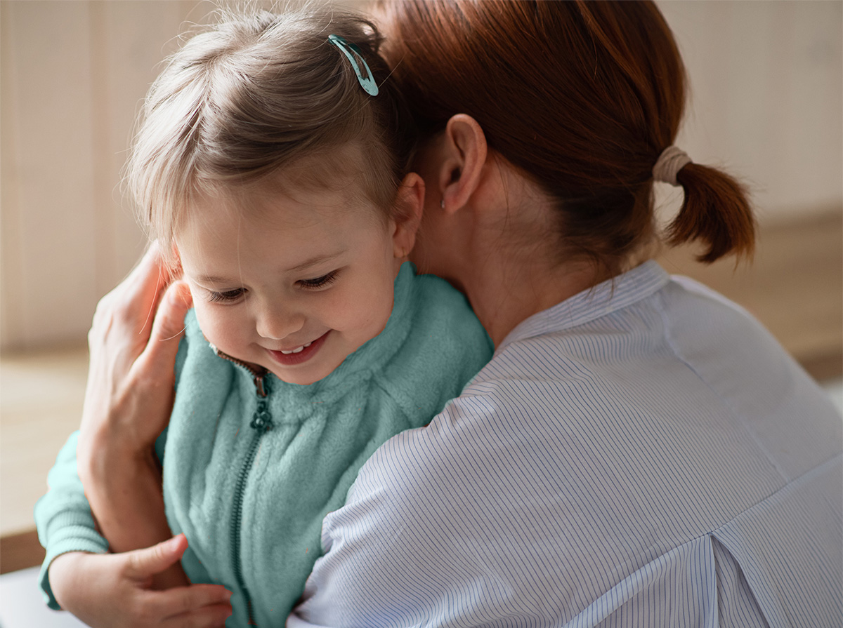 Mother hugging young girl goodbye