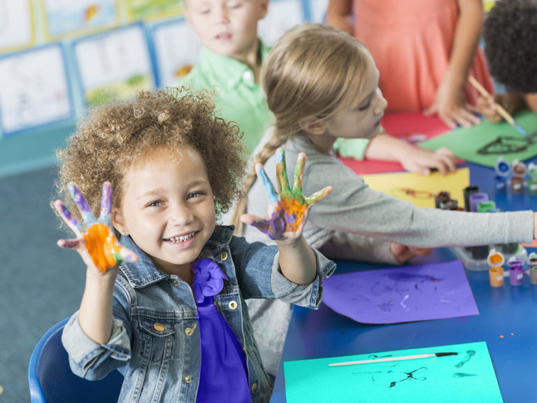 Children finger painting art in child care class