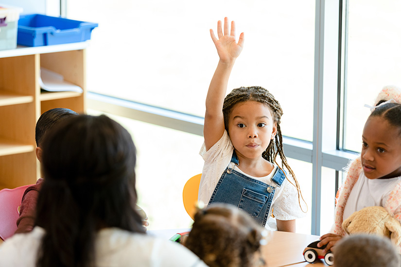 Girl raising hand at child care center