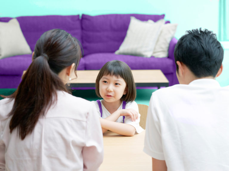 girl-sits-across-from-parents