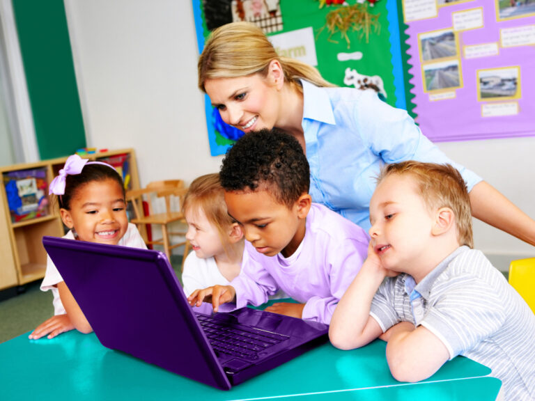 Teacher and students look at laptop