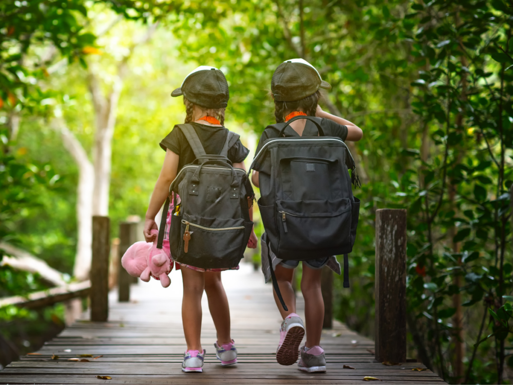 Two girls use the buddy system on a nature walk.