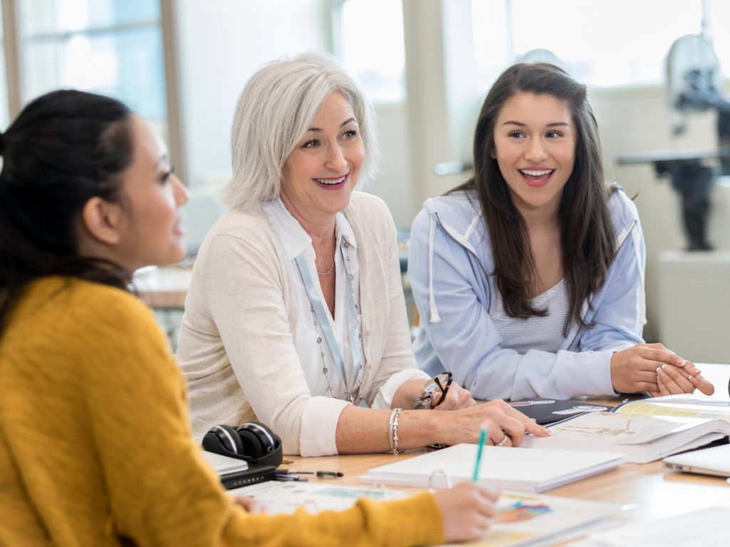 Teachers sit at a table and talk about raises.