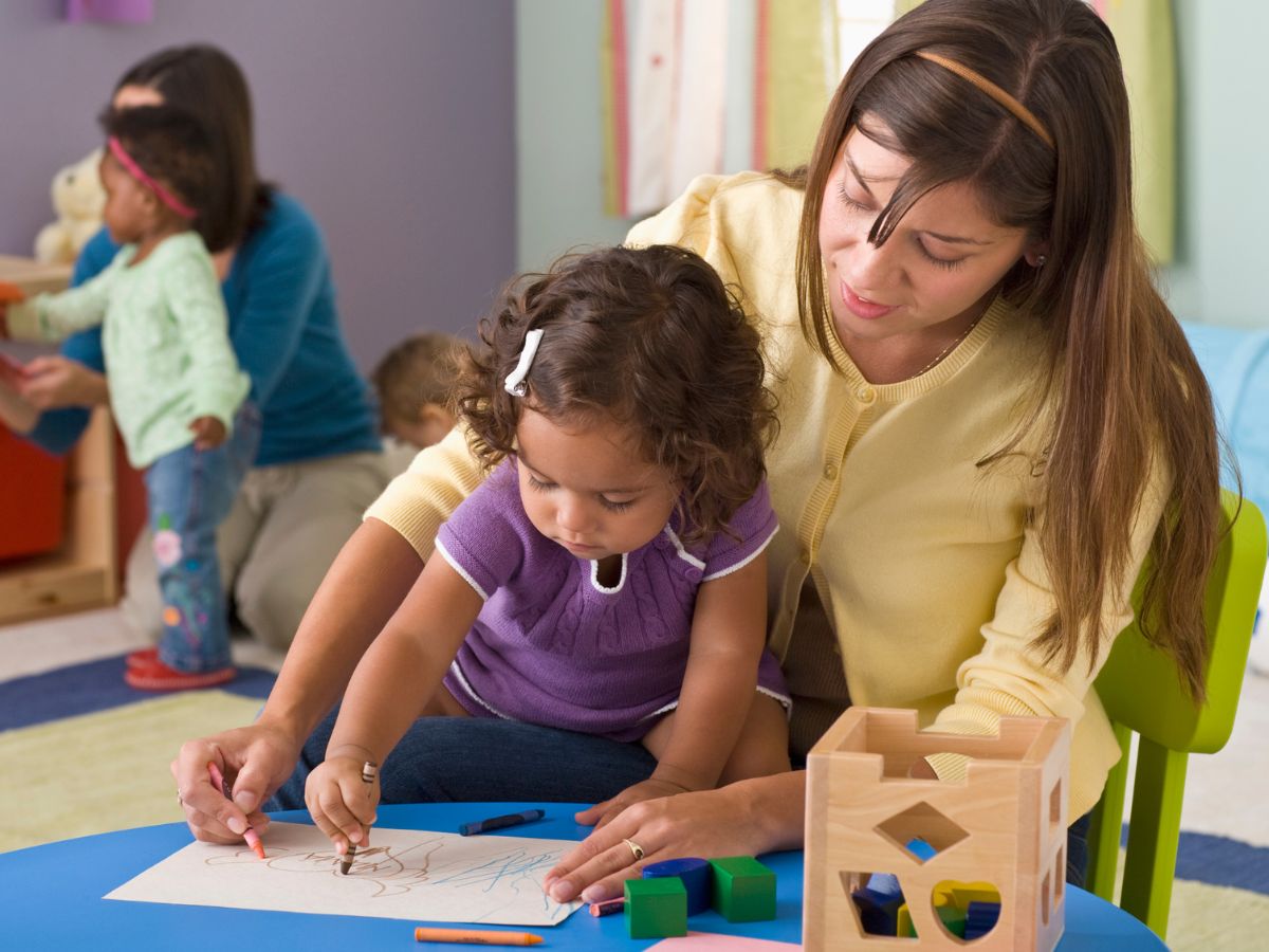 teacher and toddler coloring at daycare