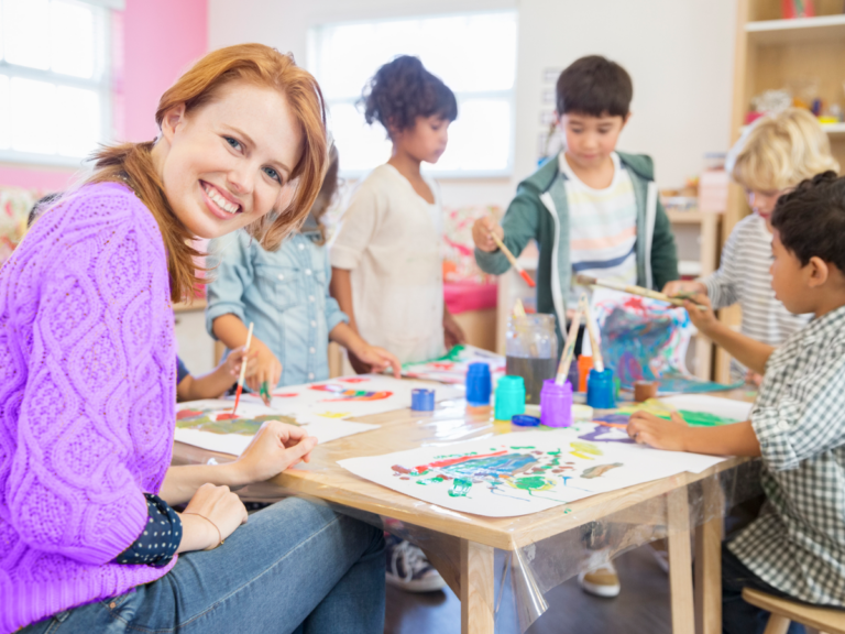 A teacher paints with her students.