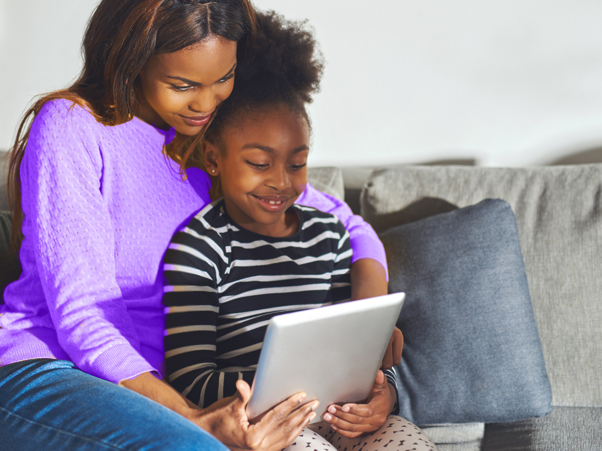 Mother and daughter view a tablet together.