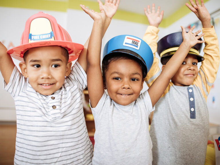 Young boys smiling with hands up